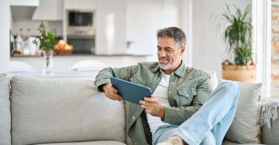 Mann mit Tablet auf der Couch