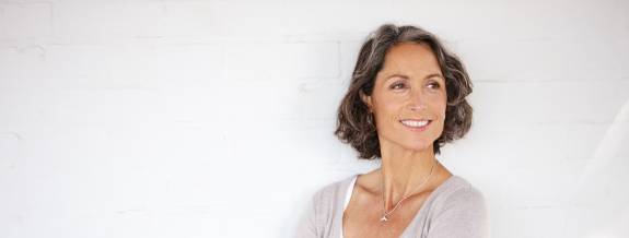 Frau auf weißem Hintergrund lächelt