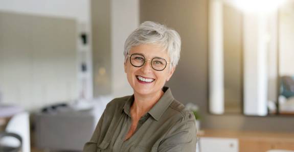 Frau mit kurzen weißen Haaren lächelt